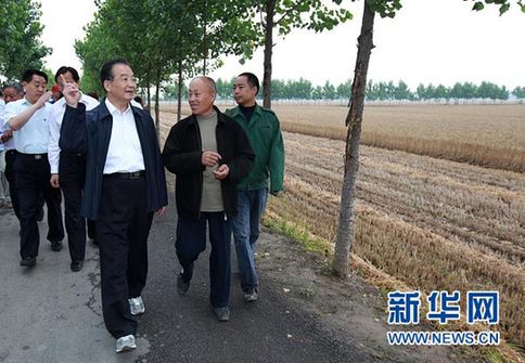 這是6月9日，溫家寶在長葛市石象鄉坡李王村的田間小路上與坡李王村支部書記李福成邊走邊聊。新華社記者龐興雷攝