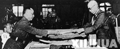 日本中國派遣軍總司令官岡村寧次在對華投降書上簽字，并向中方交出他的隨身佩刀，以表示侵華日軍正式向中國繳械投降。這是何應(yīng)欽(左)在南京代表中國政府接受侵華日軍總司令岡村寧次的投降書。新華社發(fā)