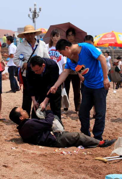 青島棧橋便衣城管毆打殘疾小販  青島棧橋便衣城管毆打殘疾小販