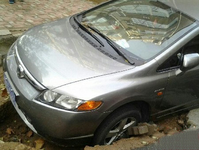 大雨過后青島一路面塌陷 來往車輛失前蹄 大雨過后青島一路面塌陷 來往車輛失前蹄