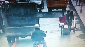 11月8日晚,鳳凰縣民俗園,許文婷(化名,紅衣者)被拖拉機車廂后門砸傷。視頻截圖/鳳凰縣公安局提供