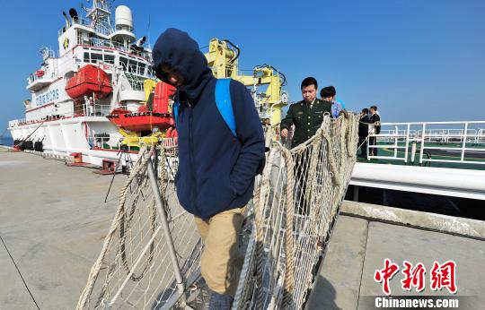 圖為24名“驢友”的“導游”被邊防的工作人員帶下船接受調查。 駱云飛 攝