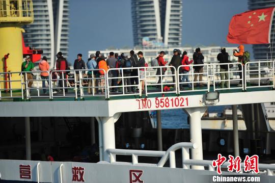 圖為24名“驢友”的“導游”被邊防的工作人員帶下船接受調查。 駱云飛 攝